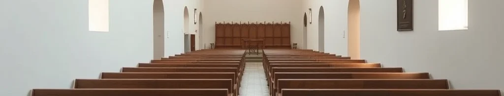 Leere Kirche mit Holzbankreihen, zentralem Mittelgang, weißen Wänden, Bögen und Rundfenster am Ende.