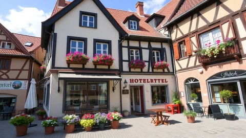 Malerische Fachwerkstraße mit Blumenkästen an Fenstern, Tischen im Freien und einem Hotel im Zentrum.
