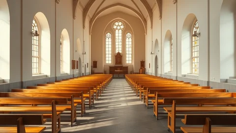Kircheninnenraum mit Holzbankreihen, hohen Bögen und lichtdurchfluteten Fenstern; Altar im Hintergrund.