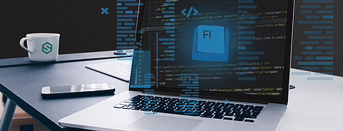 Schreibtisch mit MacBook, Code-Editor mit „FI“-Datei, schwebendem blauem Code, Tasse und Smartphone.