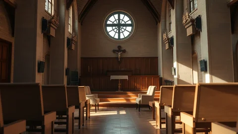 Innenraum einer Kirche mit Holzbänken, Altar, Kreuz und rundem Fenster; Licht fällt durch das Fenster.